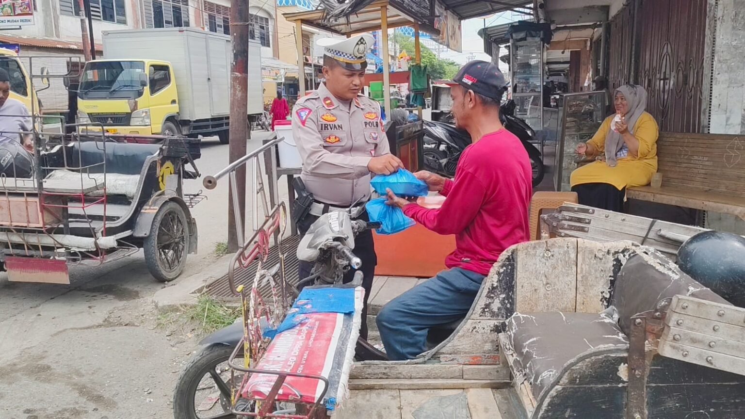 Ipda Irvan Bagikan Ratusan Nasi Kotak kepada Tukang Becak di Lhoksukon